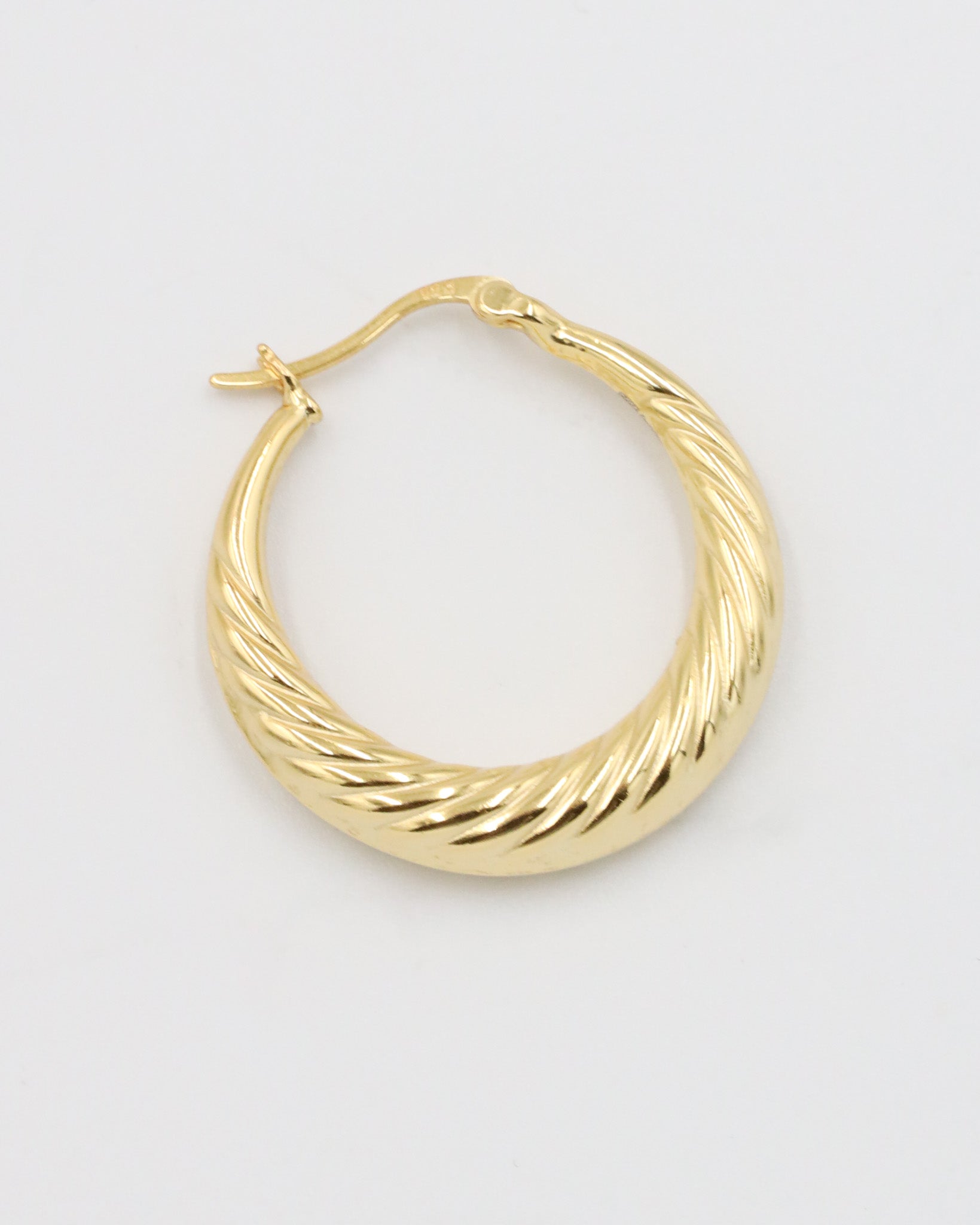 A single gold-colored hoop earring with a latch back clasp on a white background.
