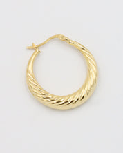 A single gold-colored hoop earring with a latch back clasp on a white background.