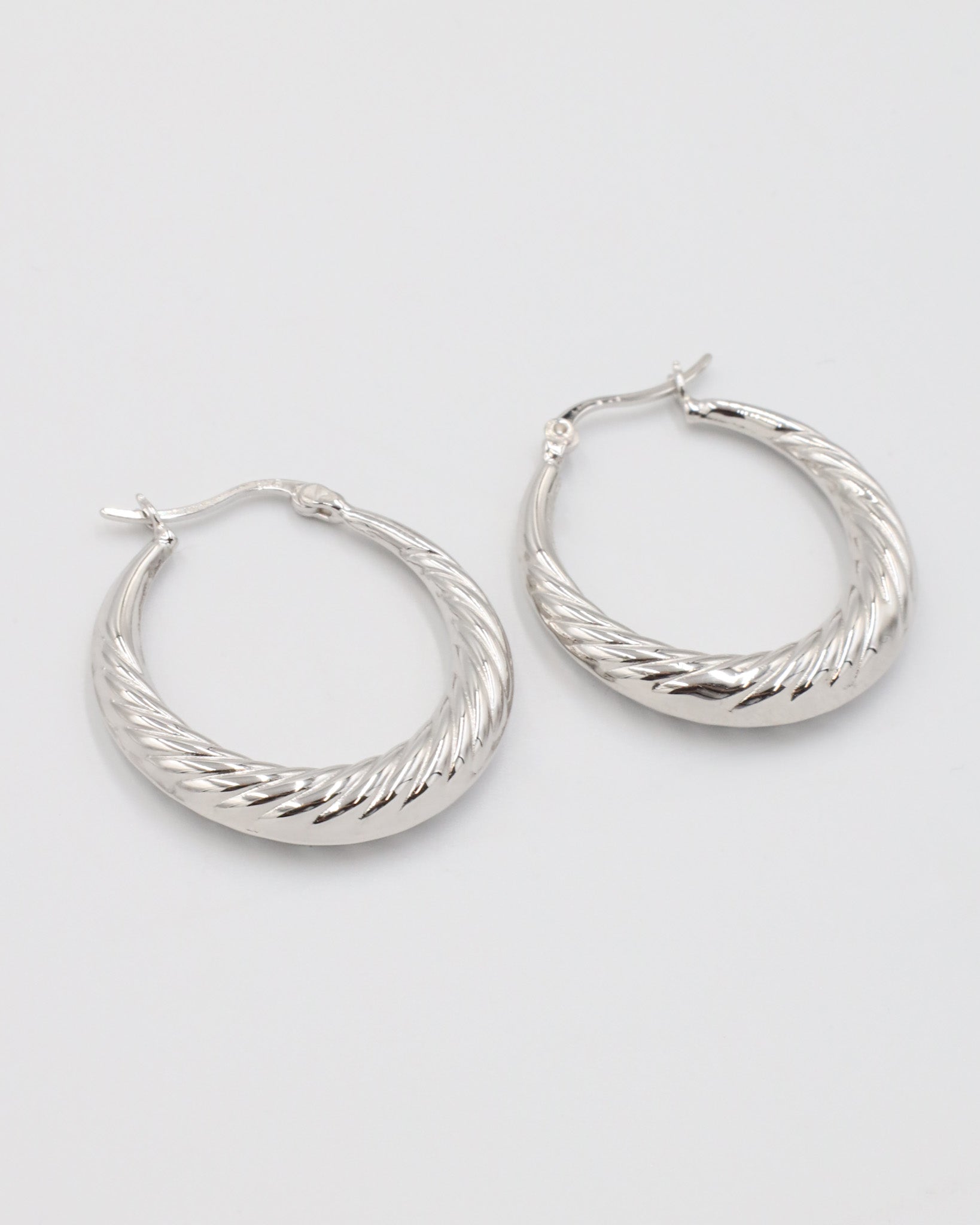 A pair of silver-colored hoop earrings with a latch back clasp.