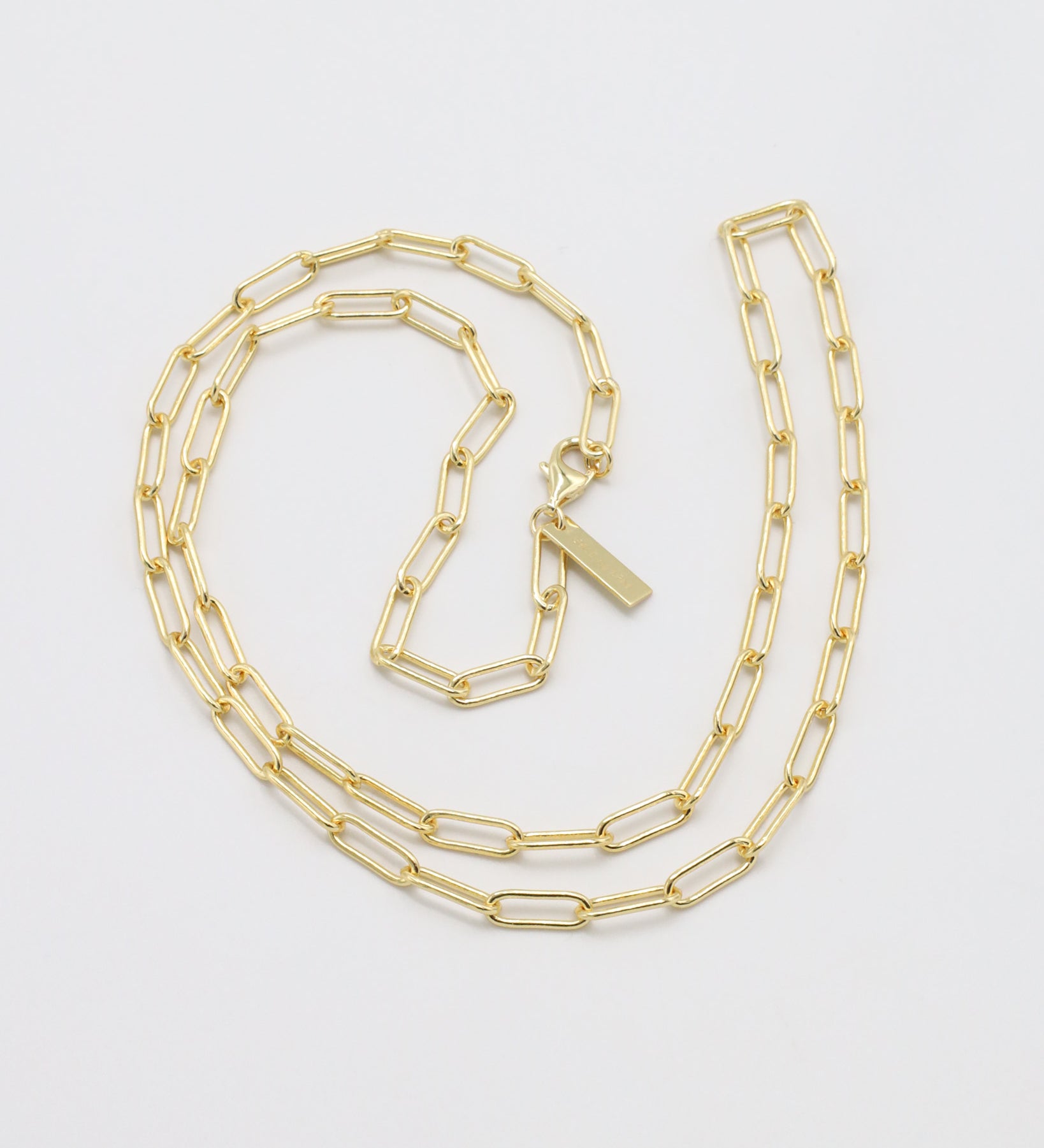 Gold chain necklace on a light gray background