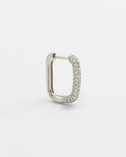 A silver hoop earring with a hinged clasp, featuring a row of small, embedded stones around the hoop.