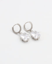 A pair of sterling silver hoop earrings with a hinged clasp and clear cubic zirconia stones.