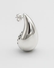 Silver teardrop-shaped earring on a light gray background