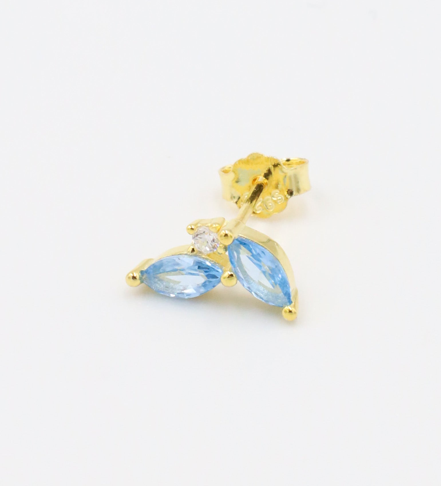Left ear gold-plated sterling silver stud earring showcasing two blue zirconia stones in a marquise cut with a central round zirconia stone.