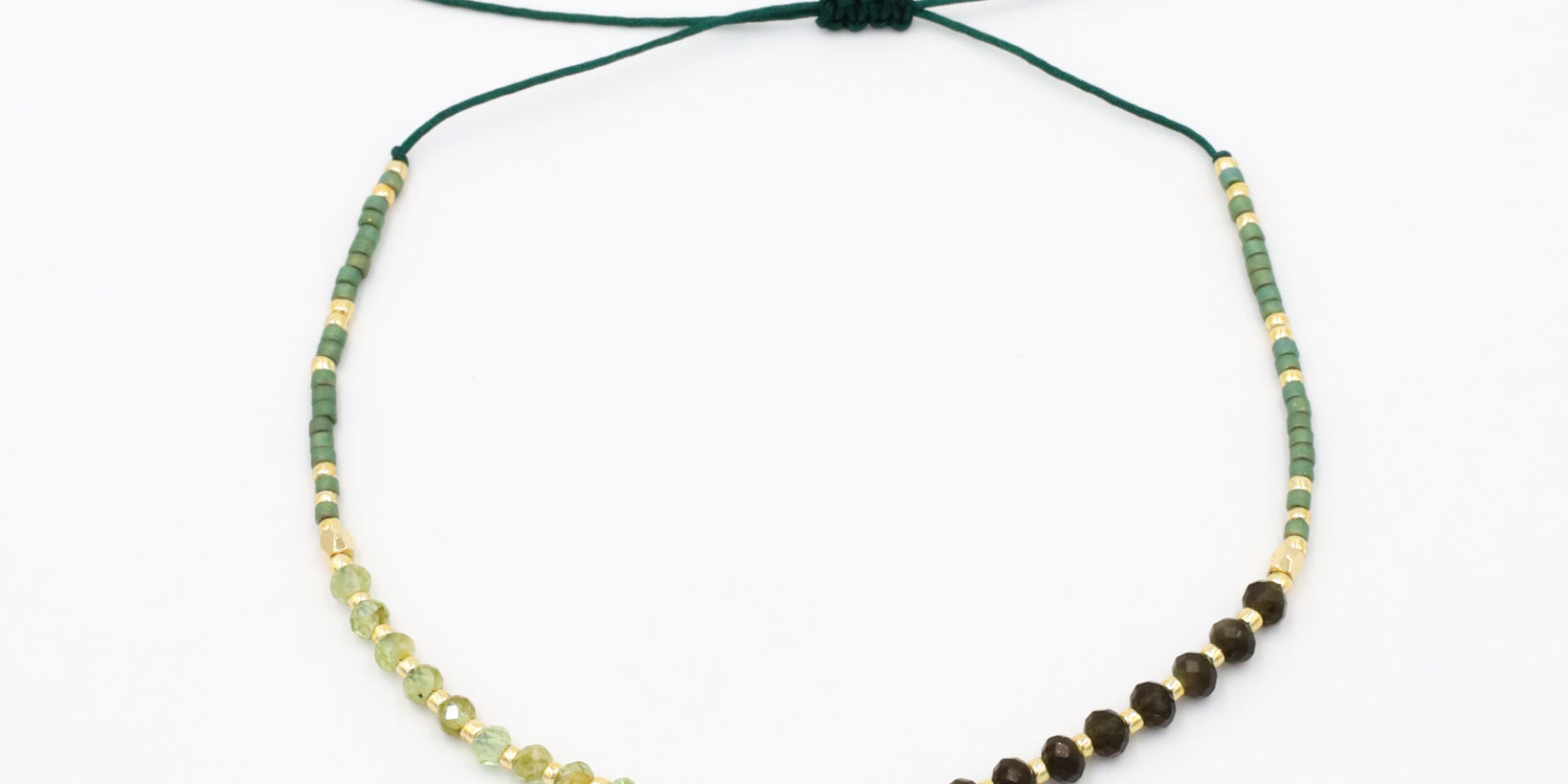 A beaded bracelet with a mix of green, gold, and brown colors, featuring rhinestones and an adjustable cord.