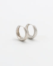 A pair of silver hoop earrings with a hinged clasp, displayed against a white background.