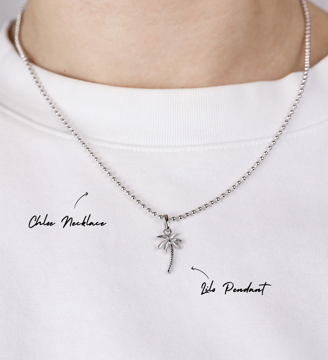 Silver necklace with a palm tree pendant on a white background