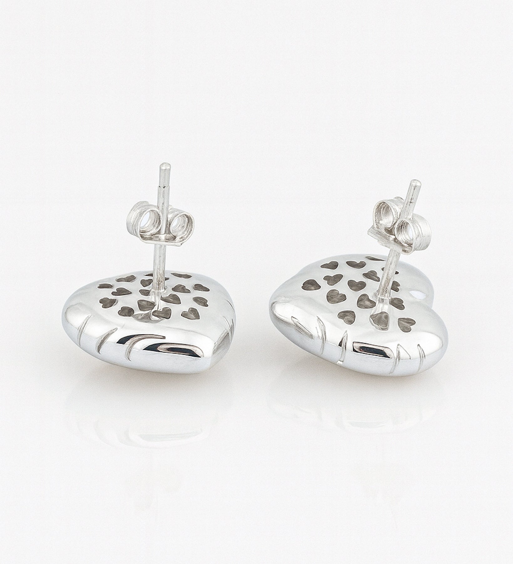 Pair of silver heart-shaped earrings with cut-out heart designs on a white background