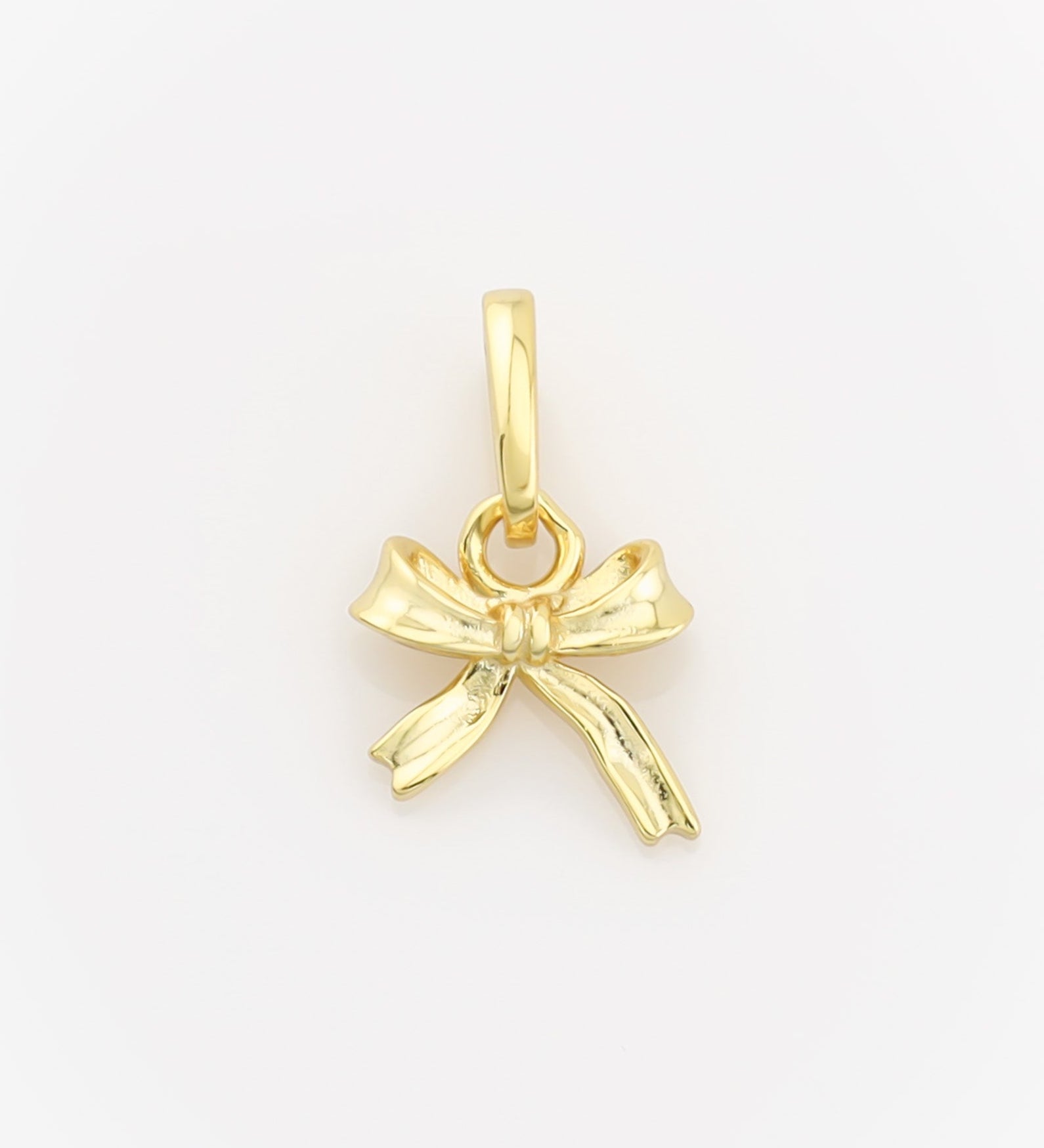Gold bow-shaped pendant on a light gray background