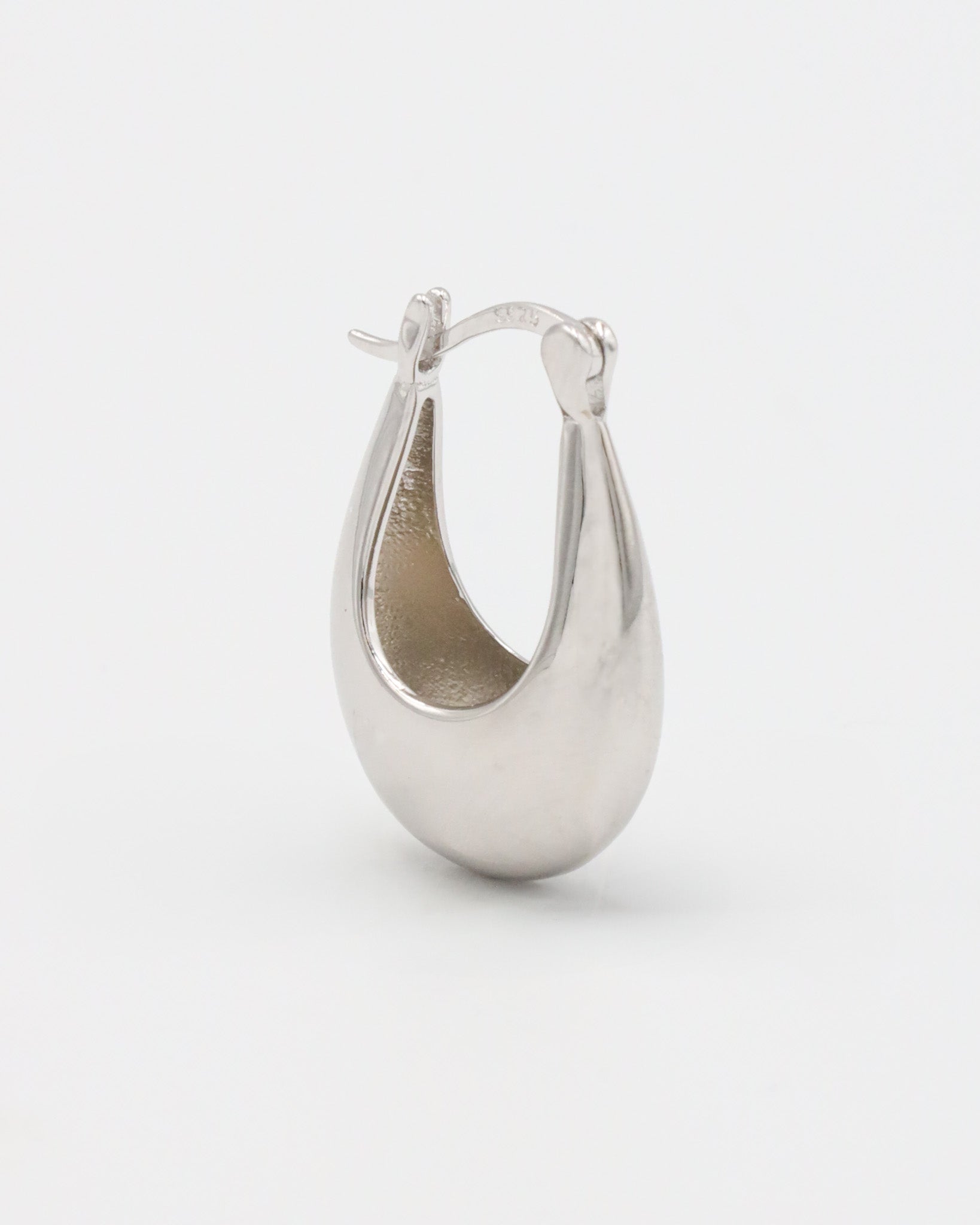This image displays a pair of elegant silver earrings, referred to as the Marigold Silver piece. The earrings feature a sleek, polished design with a smooth, curved structure that reflects light beautifully.
