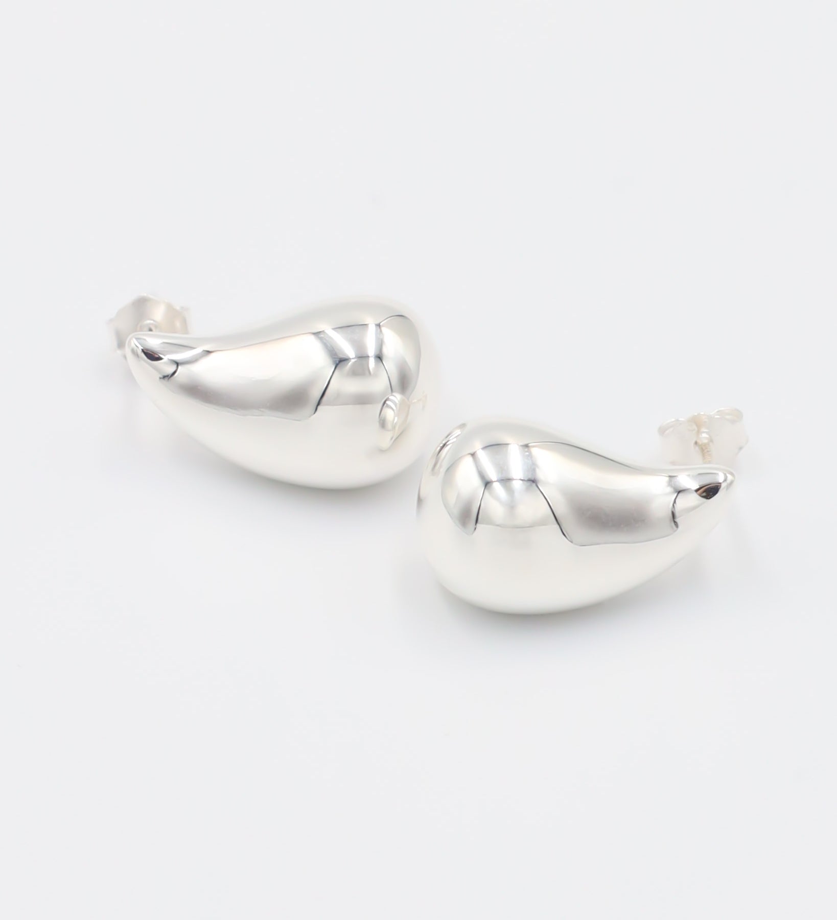 A pair of silver stud earrings with a butterfly clasp