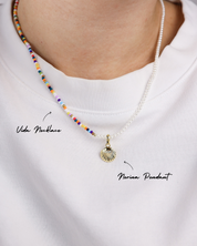 Necklace with colorful beads and a shell pendant on a white shirt