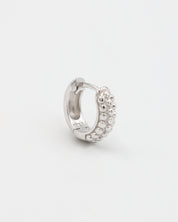 A single silver hoop earring with a pressure system anchoring and small decorative stones around the edge.
