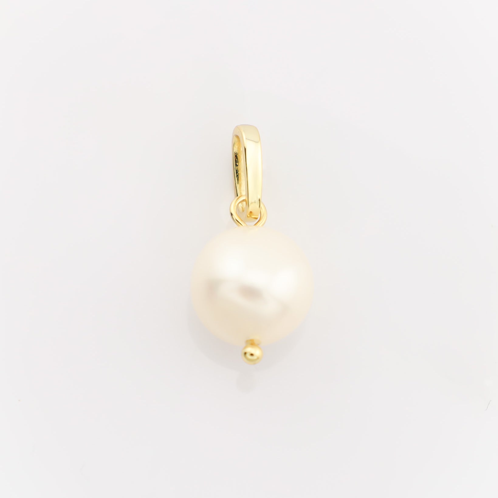 Gold pendant with a pearl on a light gray background