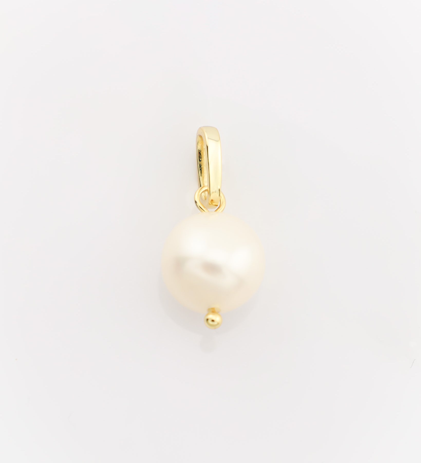 Gold pendant with a pearl on a light gray background