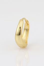 Gold hoop earring on a light gray background