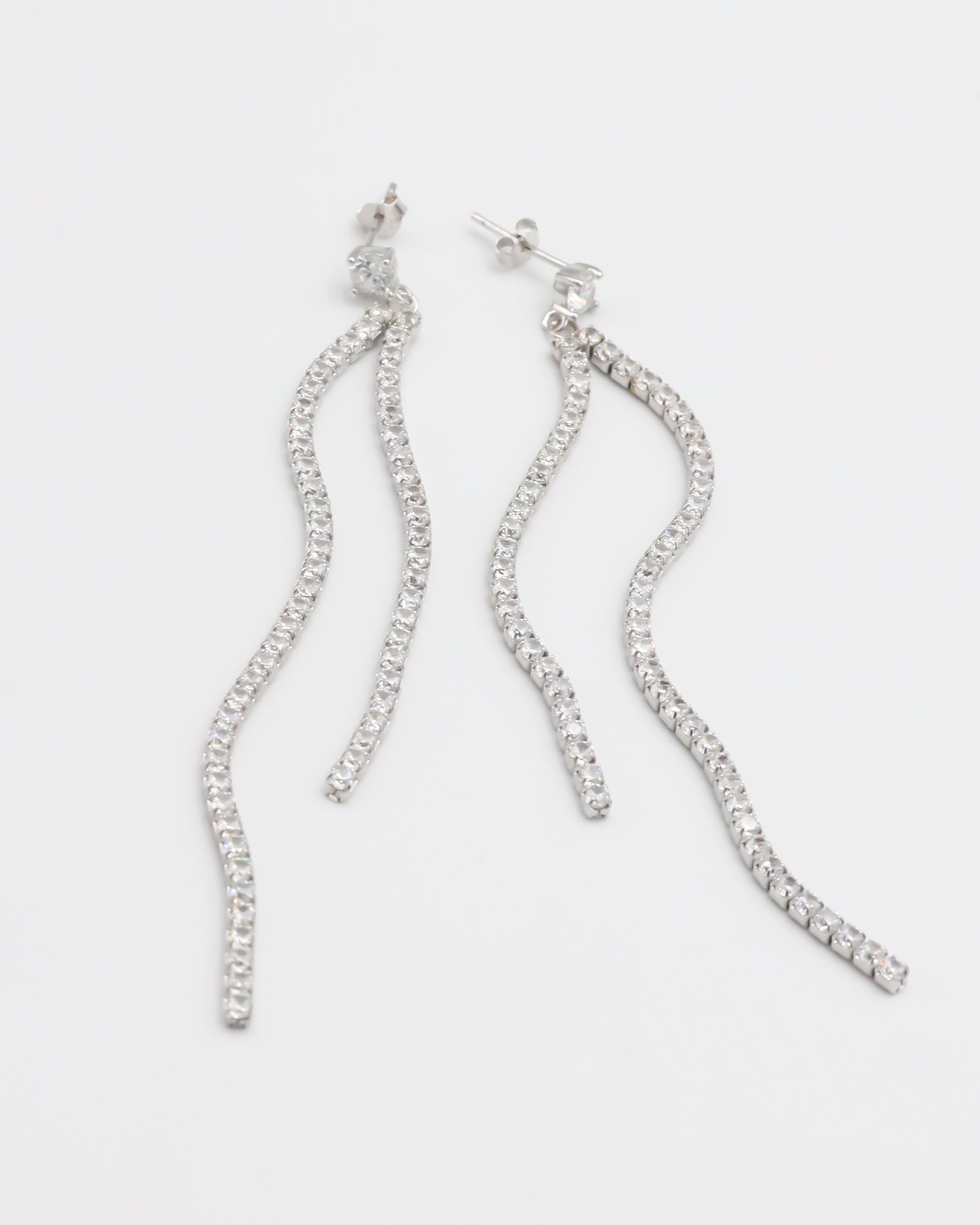A pair of silver earrings with dangling crystal embellishments.