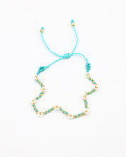 Beaded bracelet in blue, white and gold tones with a zigzag pattern and adjustable sliding closure, laid flat on a white background.