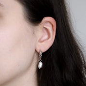 Close-up of a person wearing the Selina earring in silver on the lobe
