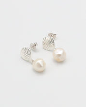 A pair of silver hoop earrings with white pearl accents on a white background.