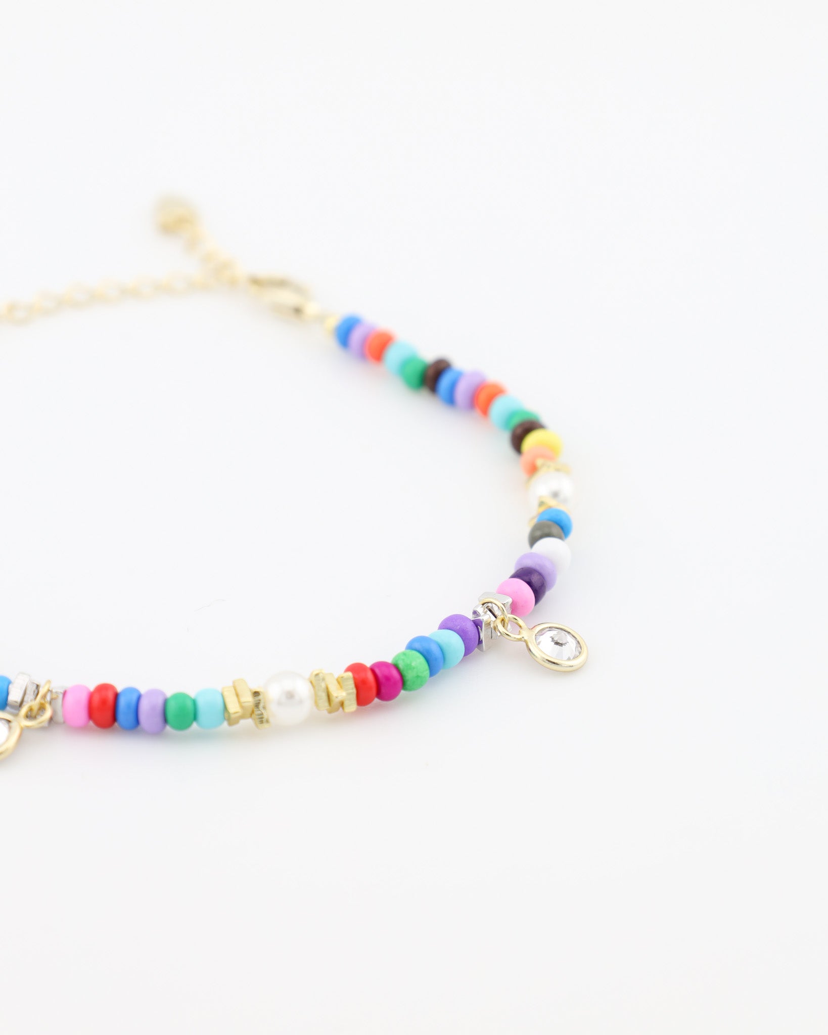 Colorful beaded bracelet with gold accents on a white background