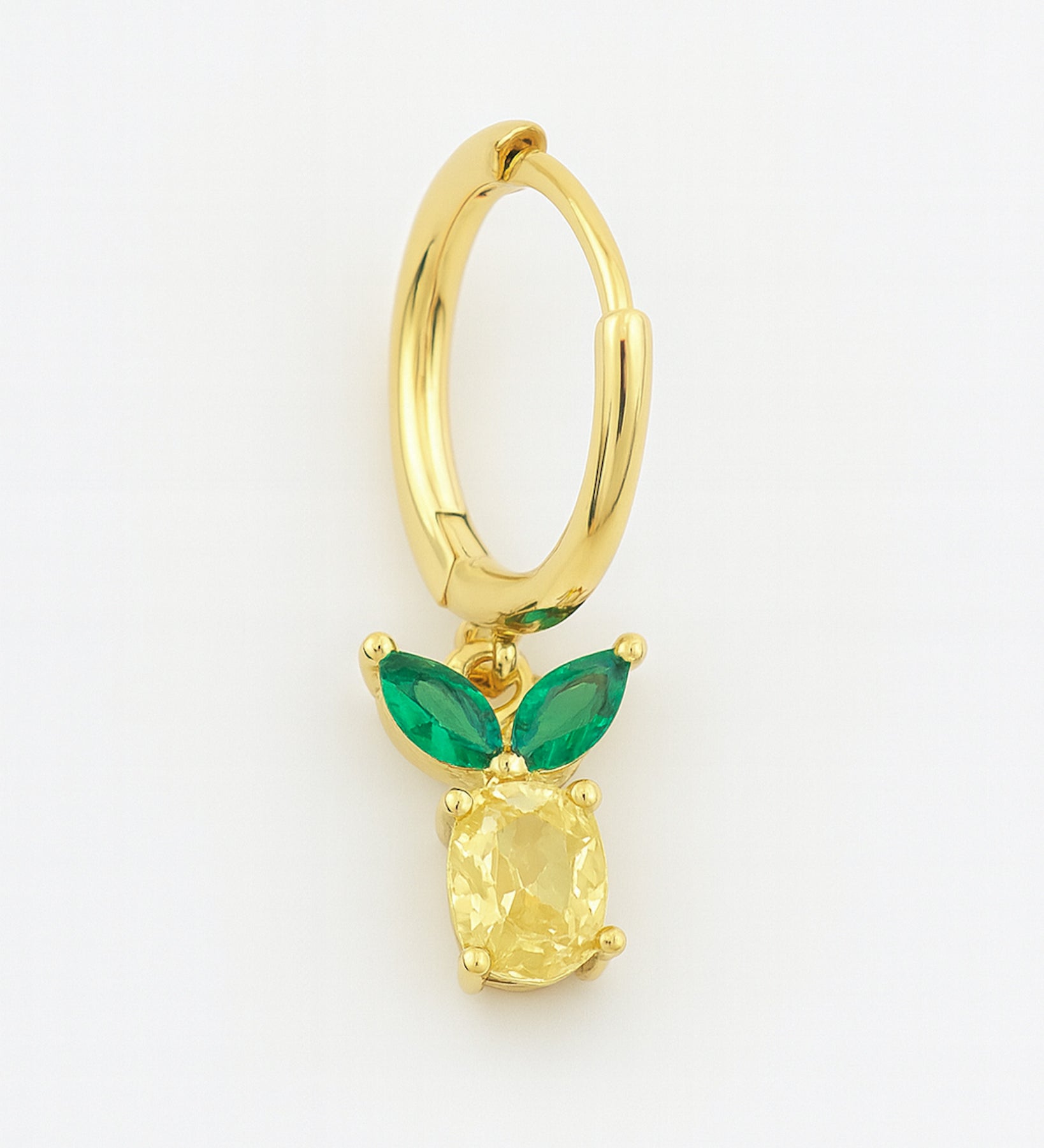 Gold hoop earring with green gemstones on a white background