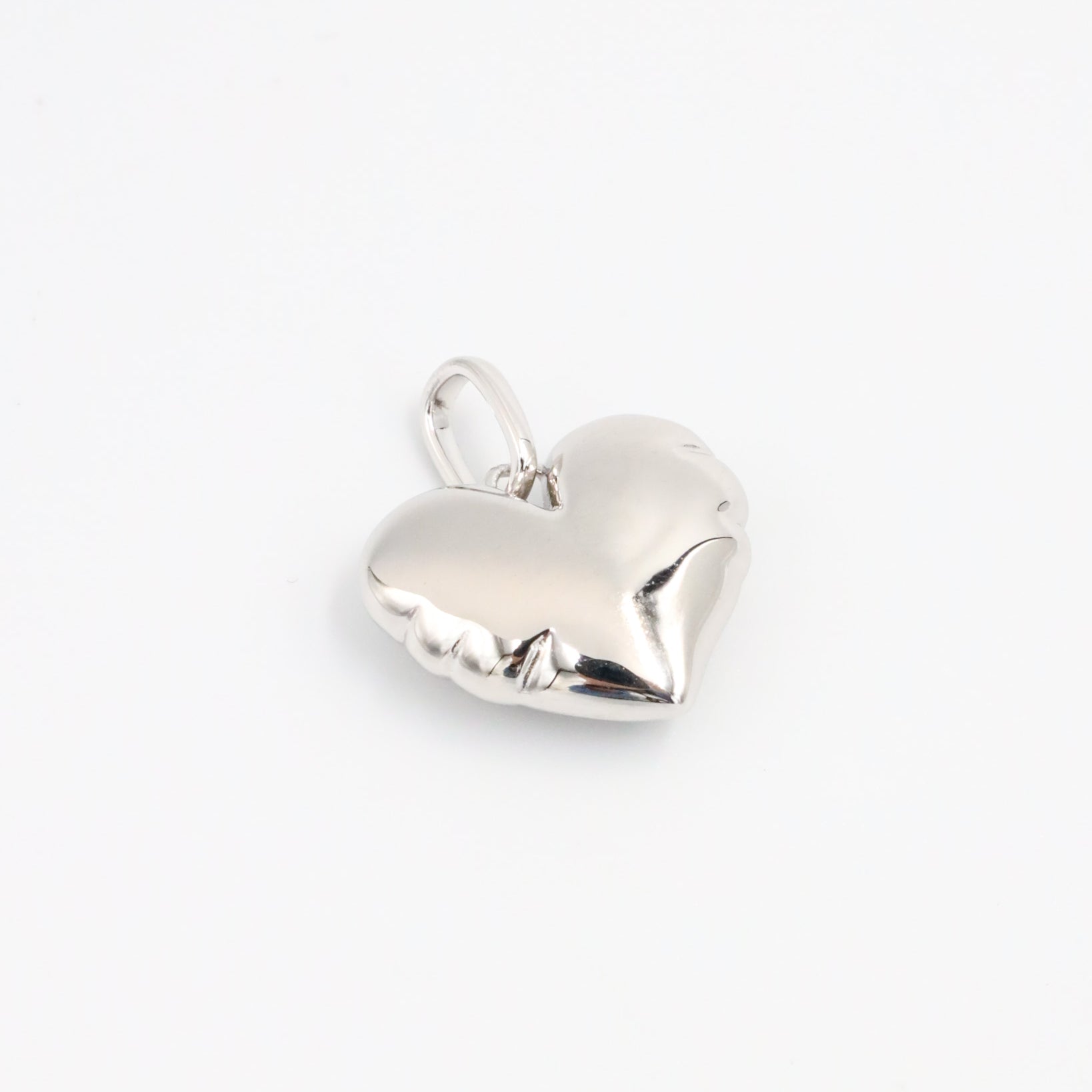 Side view of the Bella Silver heart pendant, showcasing its smooth, sculpted surface in rhodium-plated 925 sterling silver.