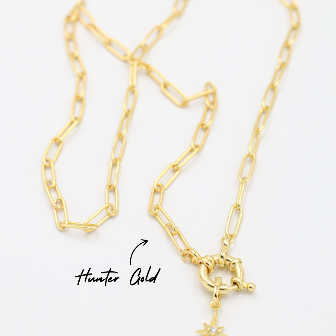 Gold star-shaped pendant with a zirconia stone, paired with a chain necklace.