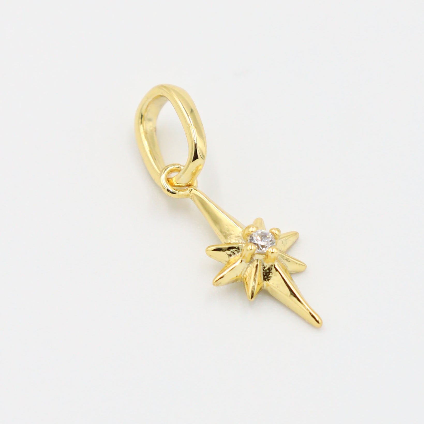 Close-up of a gold star pendant, showcasing the zirconia stone centerpiece.