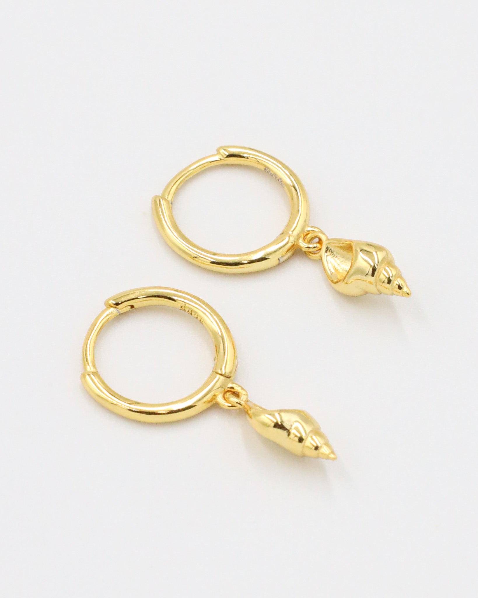 A pair of "Maddy" earrings, crafted from gold-plated 925 sterling silver, with seashell charms dangling from hoops for a beach-inspired look.