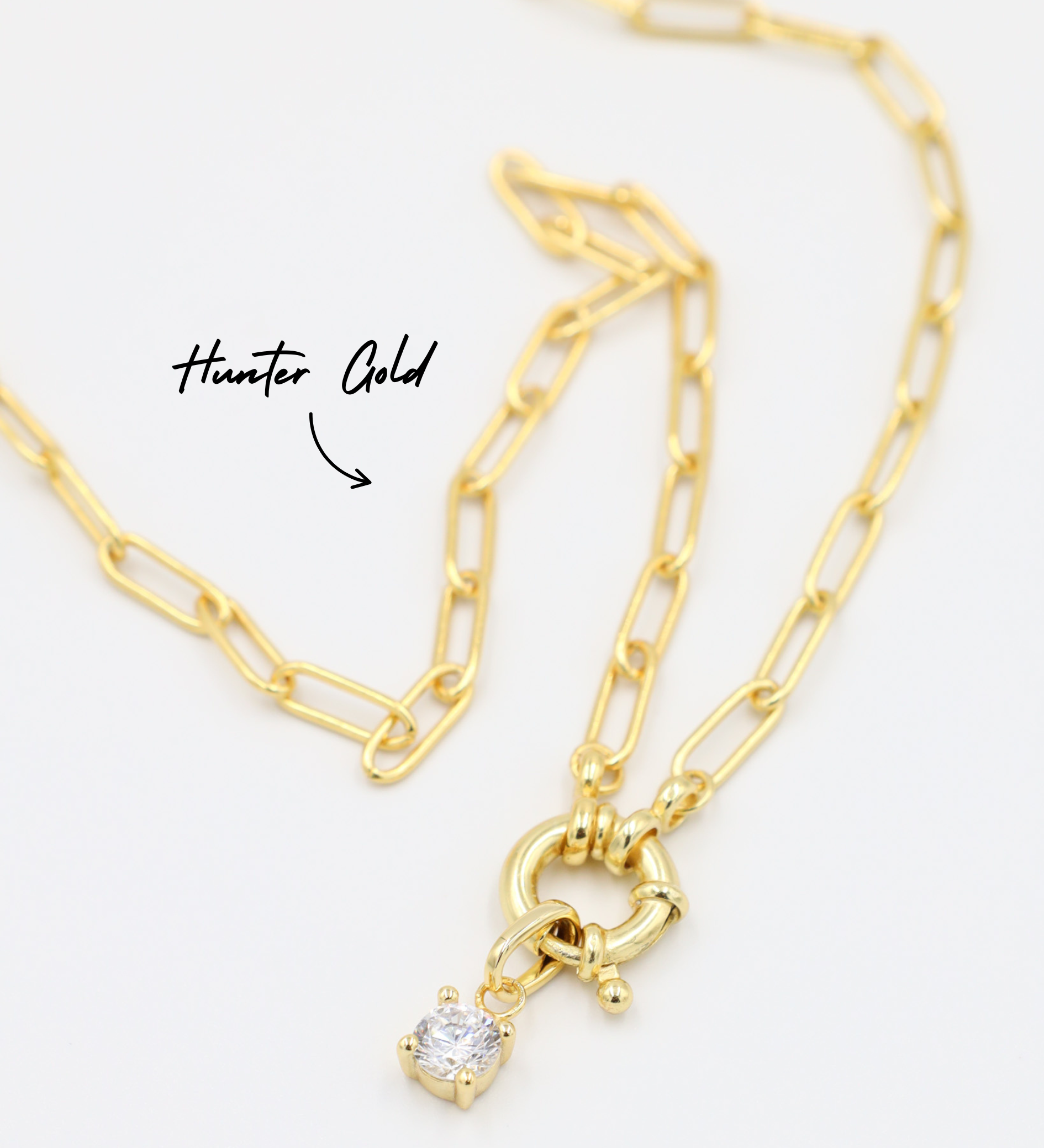 Riley Gold Pendant with zirconia stone, styled with a gold chain necklace.