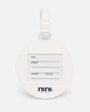 Back of the ruru. studios Smiley suitcase tag with address card and white loop on a clean white background