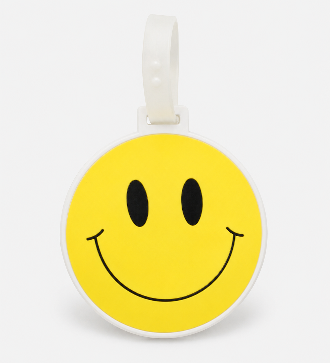 Smiley suitcase tag by ruru. studios with a yellow smiley face and white loop on a clean white background