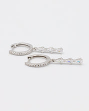 Side view of sterling silver drop earrings with a row of sparkling teardrop-shaped cubic zirconia stones.